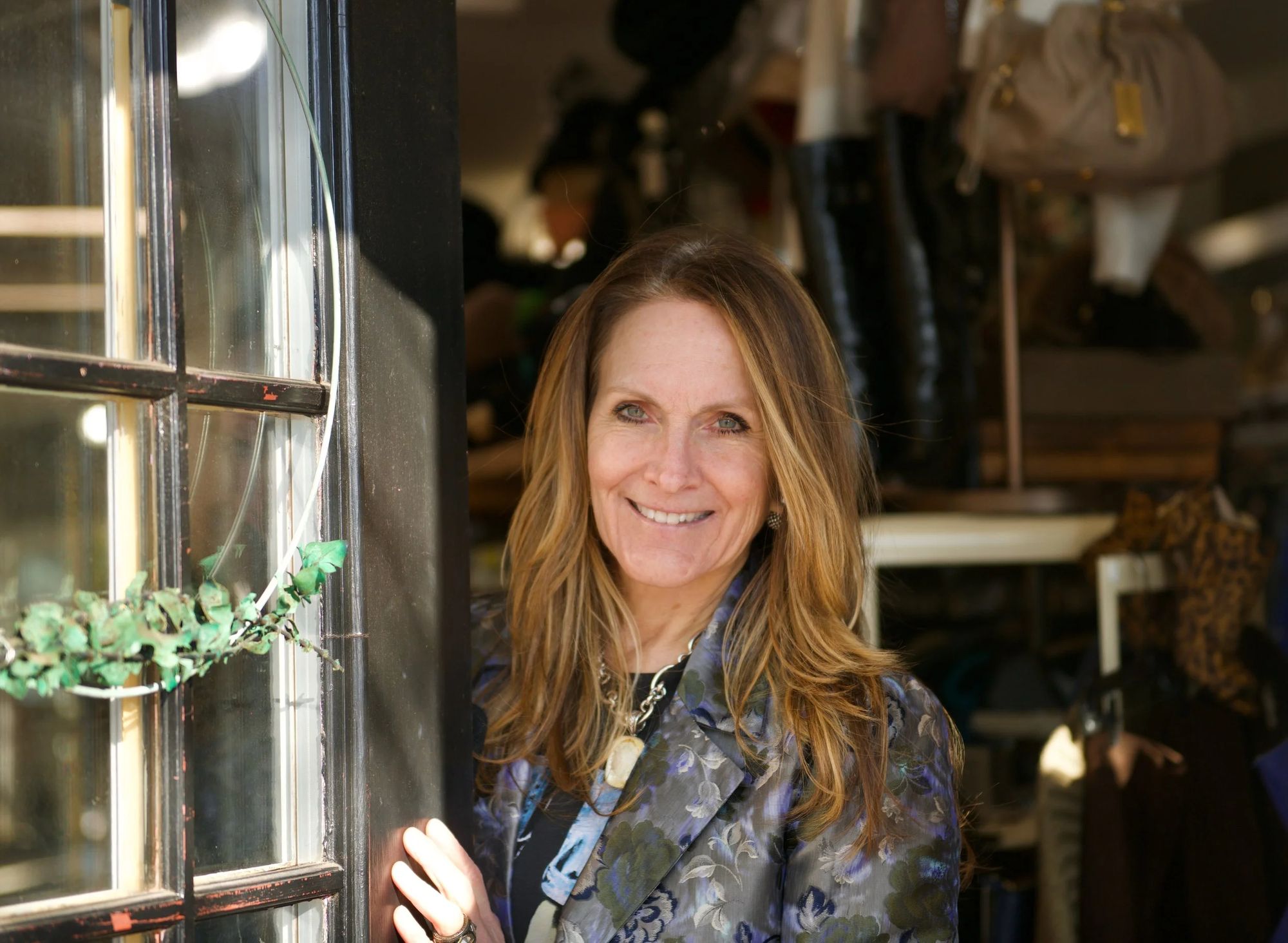 Denise Jonasz smiling in the doorway of Pure Couture