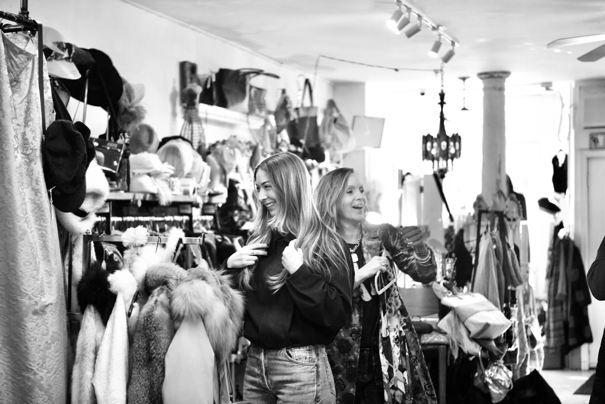 Shoppers browsing packed racks inside Pure Couture, in black and white